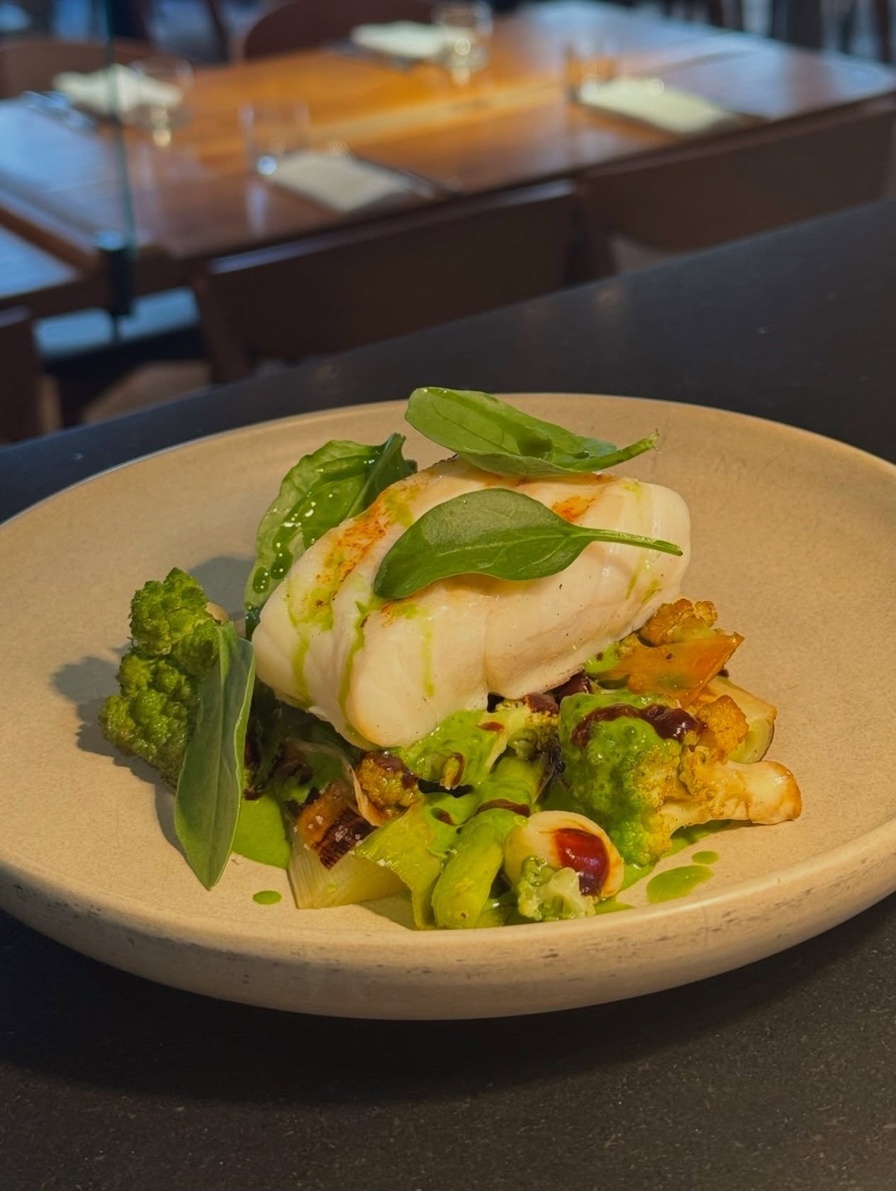 Plat de poisson accompagné de légumes verts au restaurant Elmer à Paris
