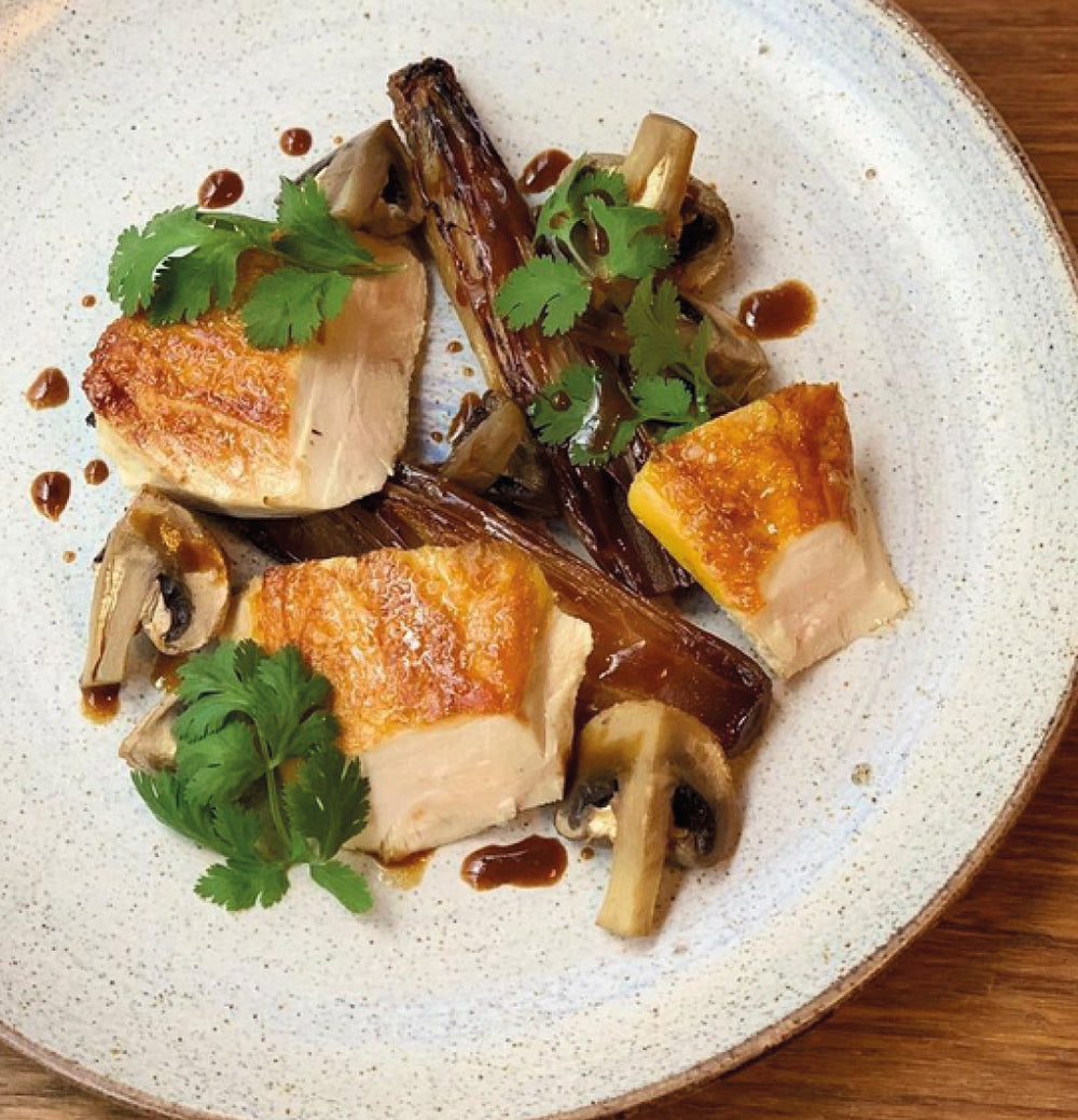 Assiette de volaille rôtie accompagnée de légumes et champignons au restaurant Elmer à Paris
