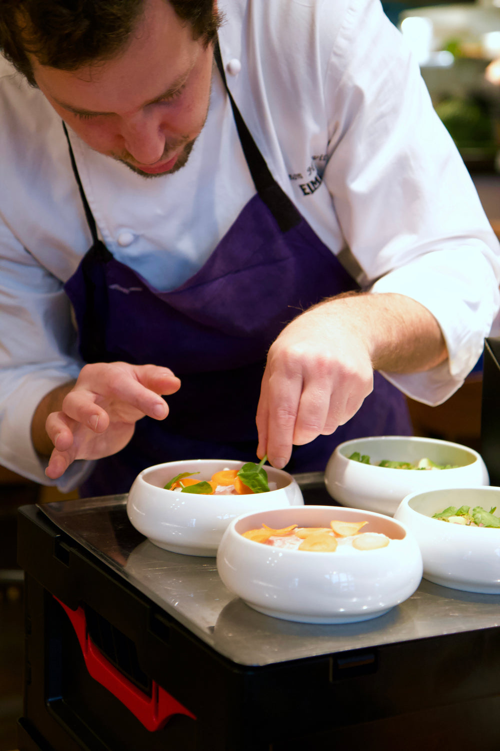 Dressage des assiettes par l’équipe en cuisine du restaurant Elmer à Paris